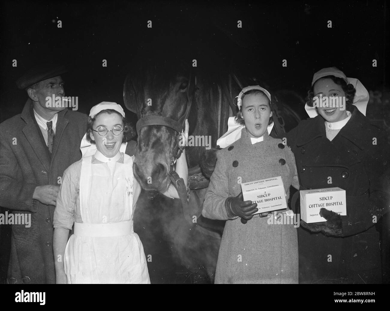 Sidcup Cottage Hospital carol infermieri di canto con le loro scatole di raccolta e cavallo . 1935 Foto Stock
