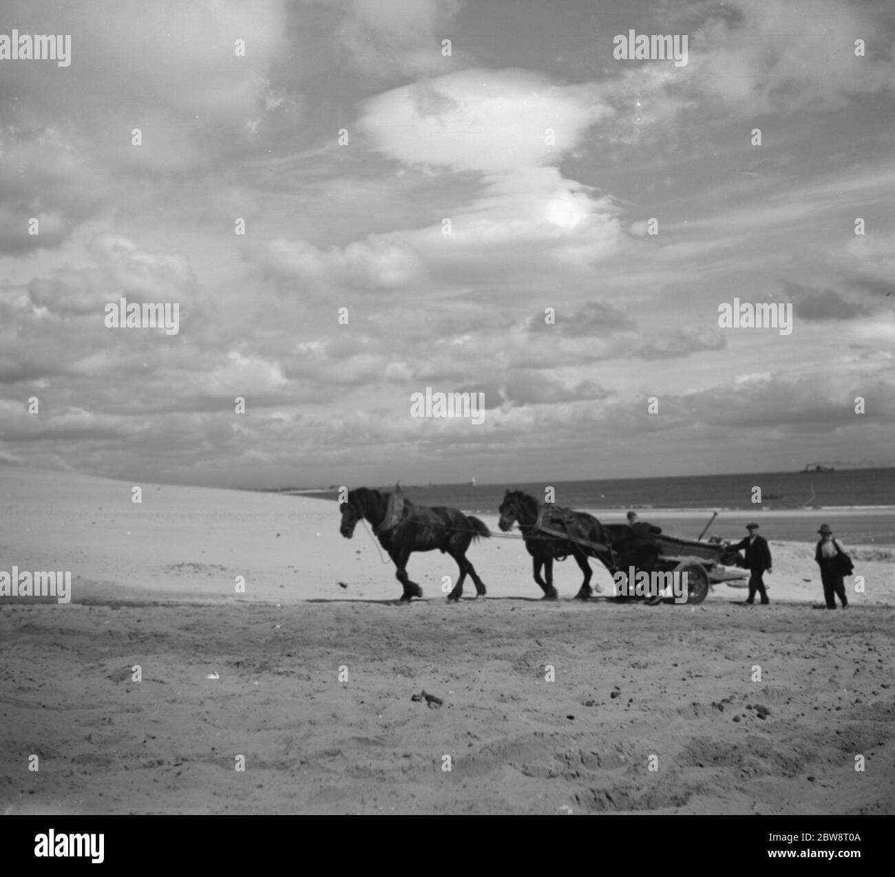 La gente del posto riempie un cavallo e un carrello di sabbia . 1936 Foto Stock