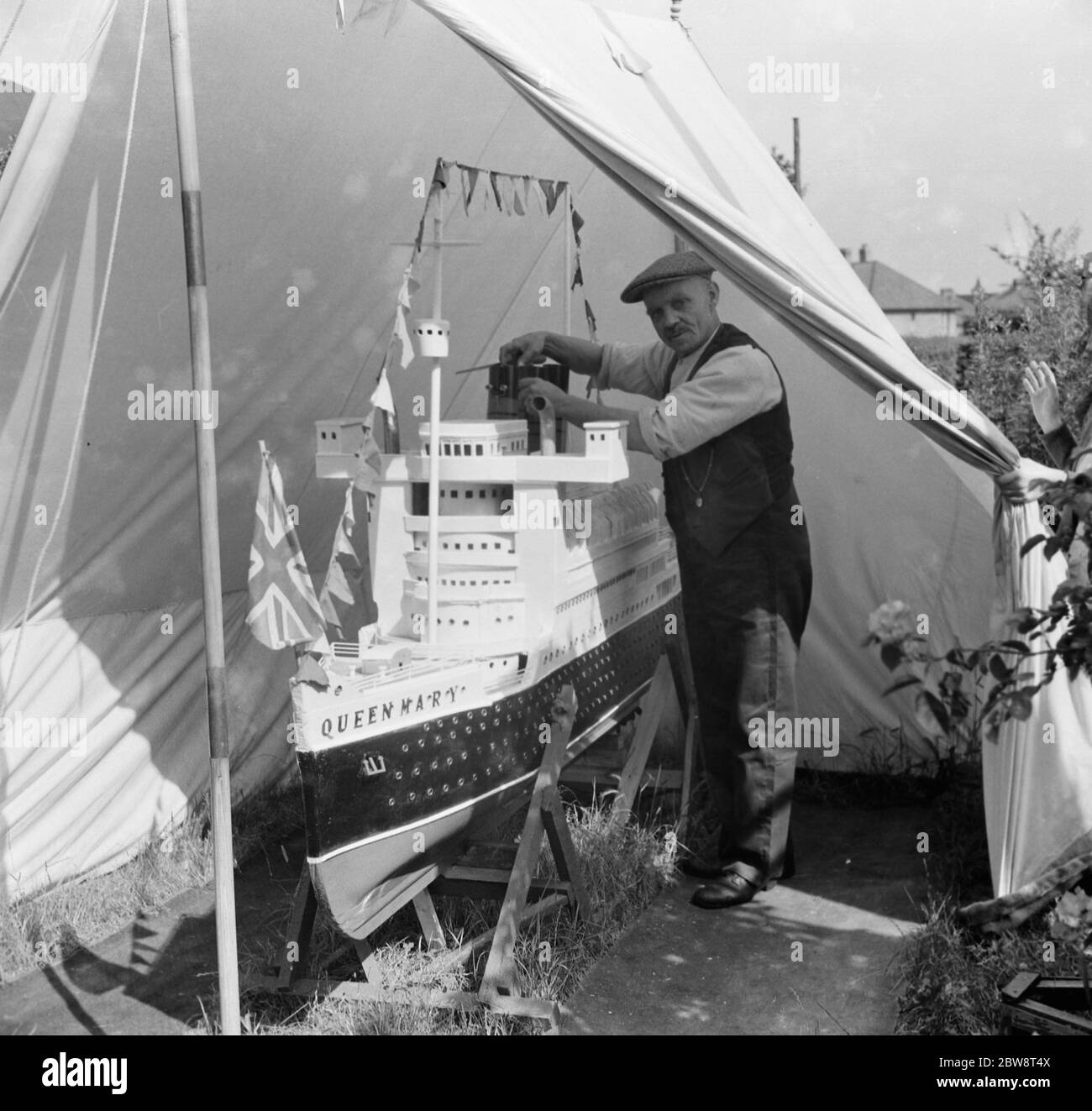 Un uomo lavora su un modello della regina Maria RMS . 1936 Foto Stock