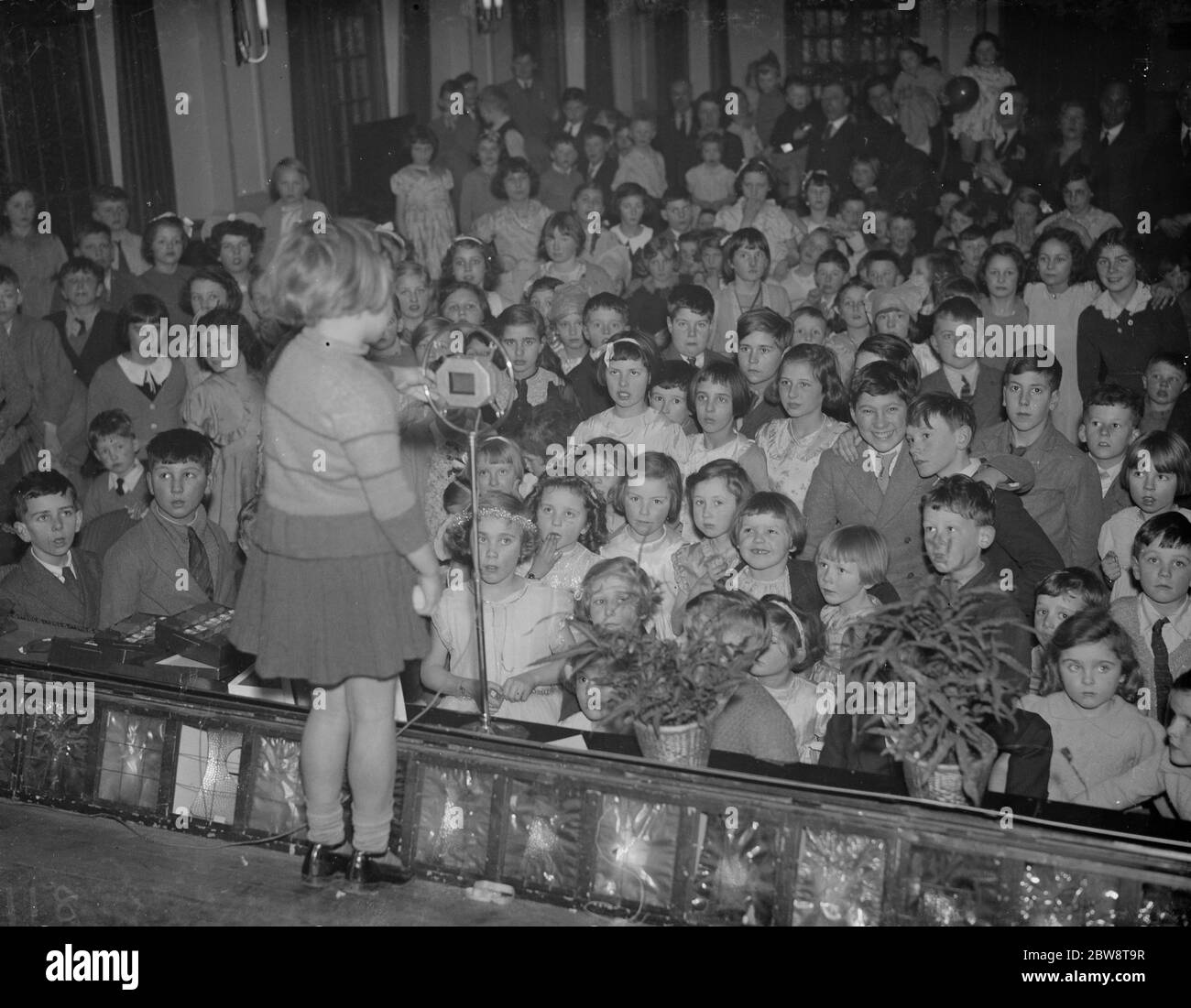 Una bambina intrattiene il pubblico dei bambini alla festa dei bambini alla GEA Hall di Petts Wood , Kent . 1938 Foto Stock
