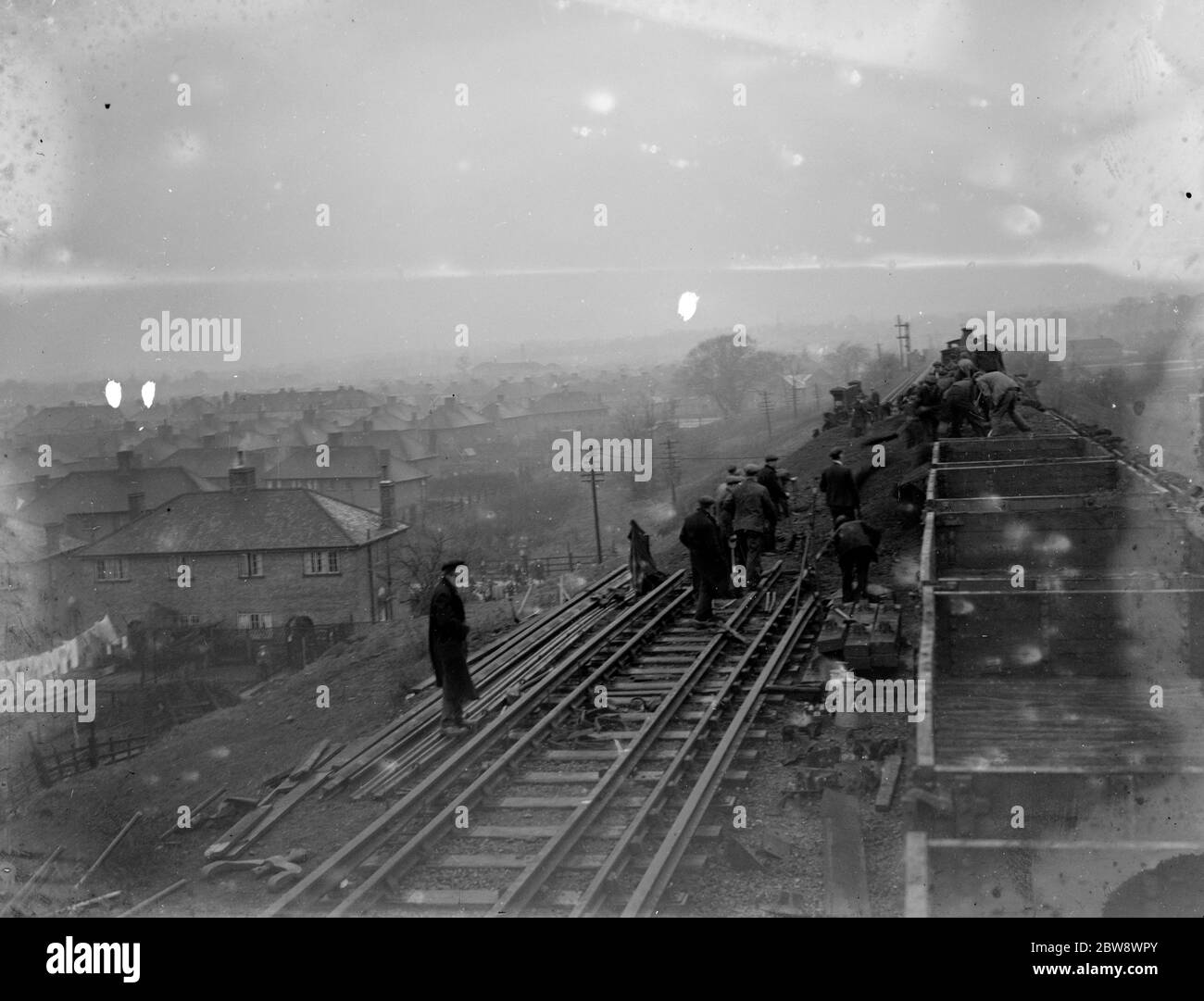 I lavoratori ferroviari lavorano per liberare lo scivolo terrestre e riappoggiare la pista sulla linea ferroviaria Wellhall . . 1936 Foto Stock