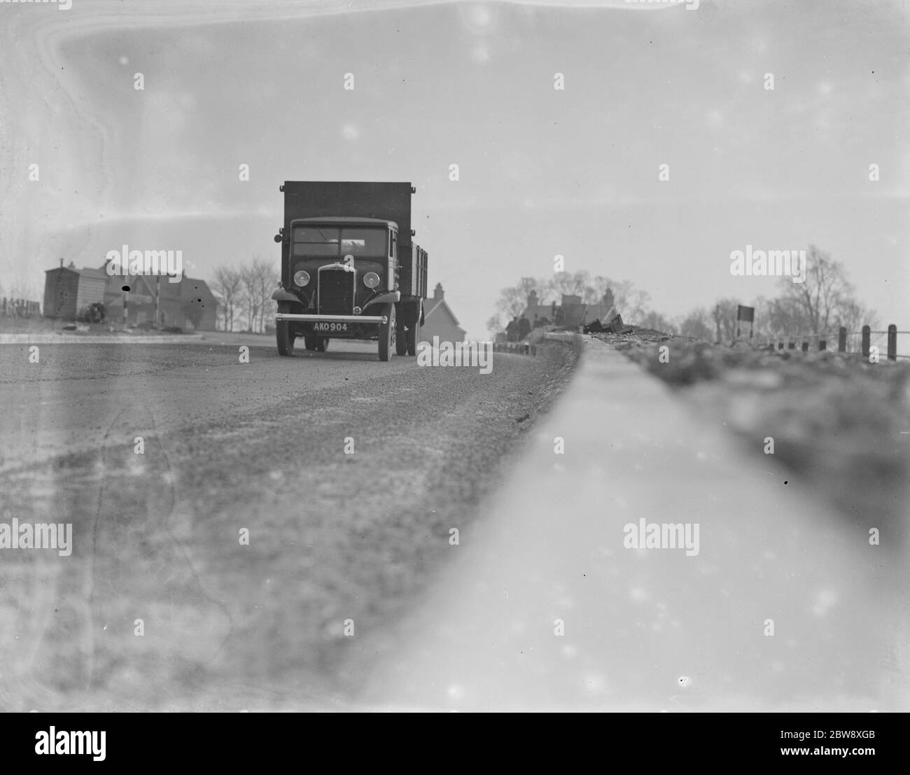 Un camion scende lungo la strada - visto dal bordo del marciapiede . 1936 Foto Stock
