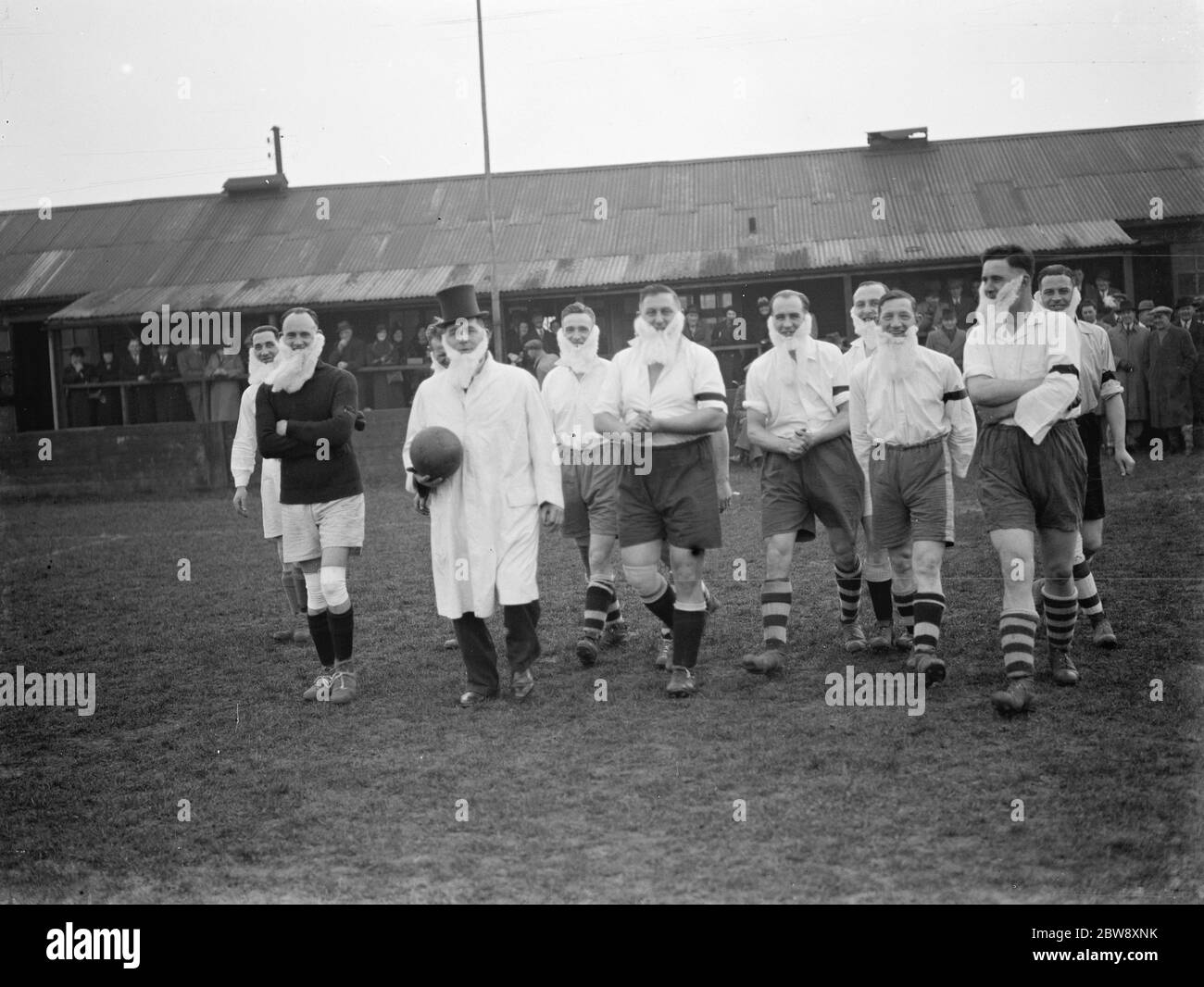 Il Woolwich Metropolitan Police Football Club partecipa a una partita di calcio di novità . La squadra e le loro barbe camminano sul campo . 1939 Foto Stock