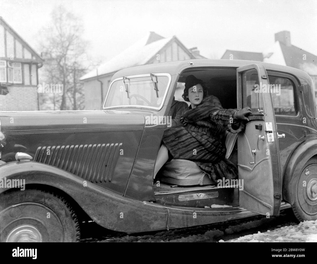 La sig.ra Muriel Oxford è seduta sul sedile passeggero di un'auto sul lato della strada. 1937 Foto Stock