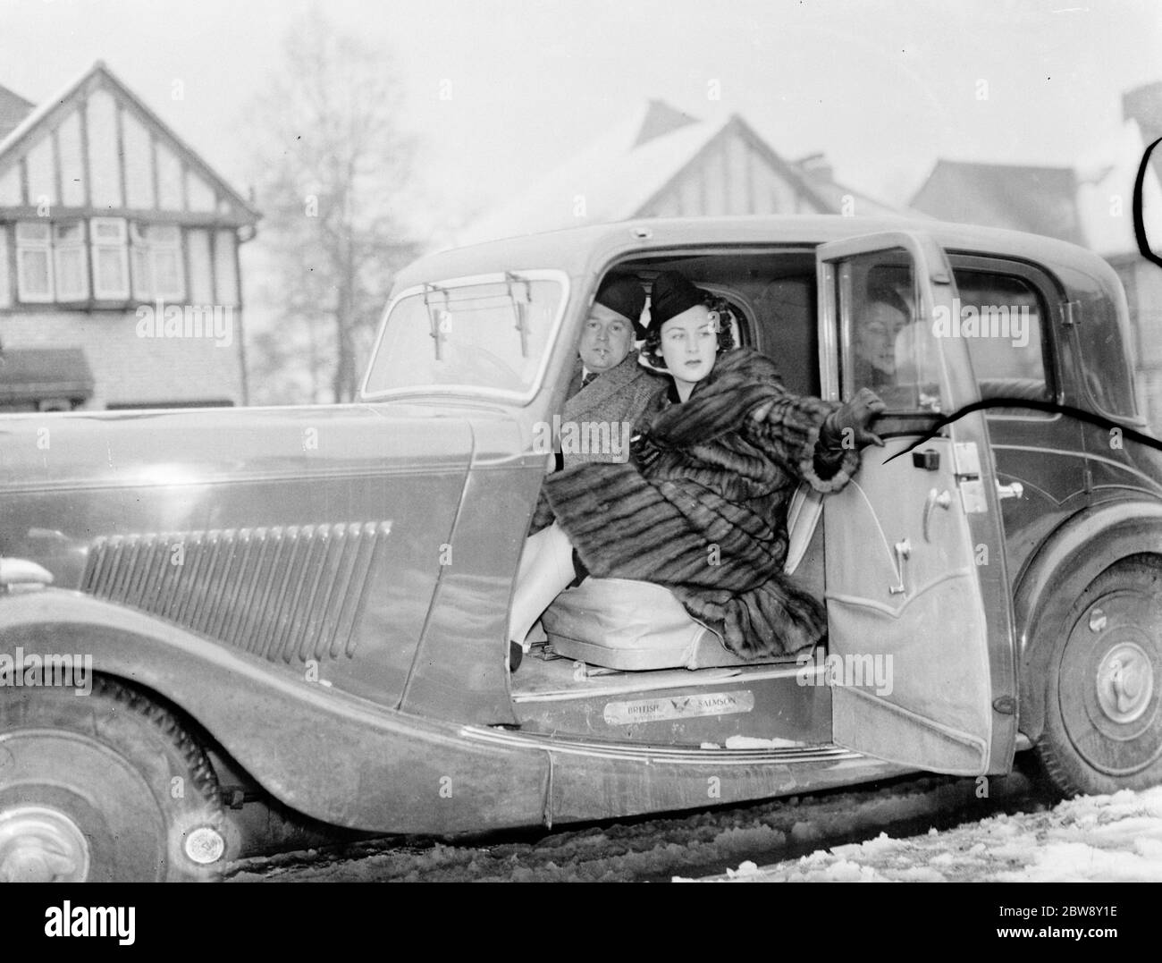La sig.ra Muriel Oxford è seduta sul sedile passeggero di un'auto sul lato della strada. 1937 Foto Stock