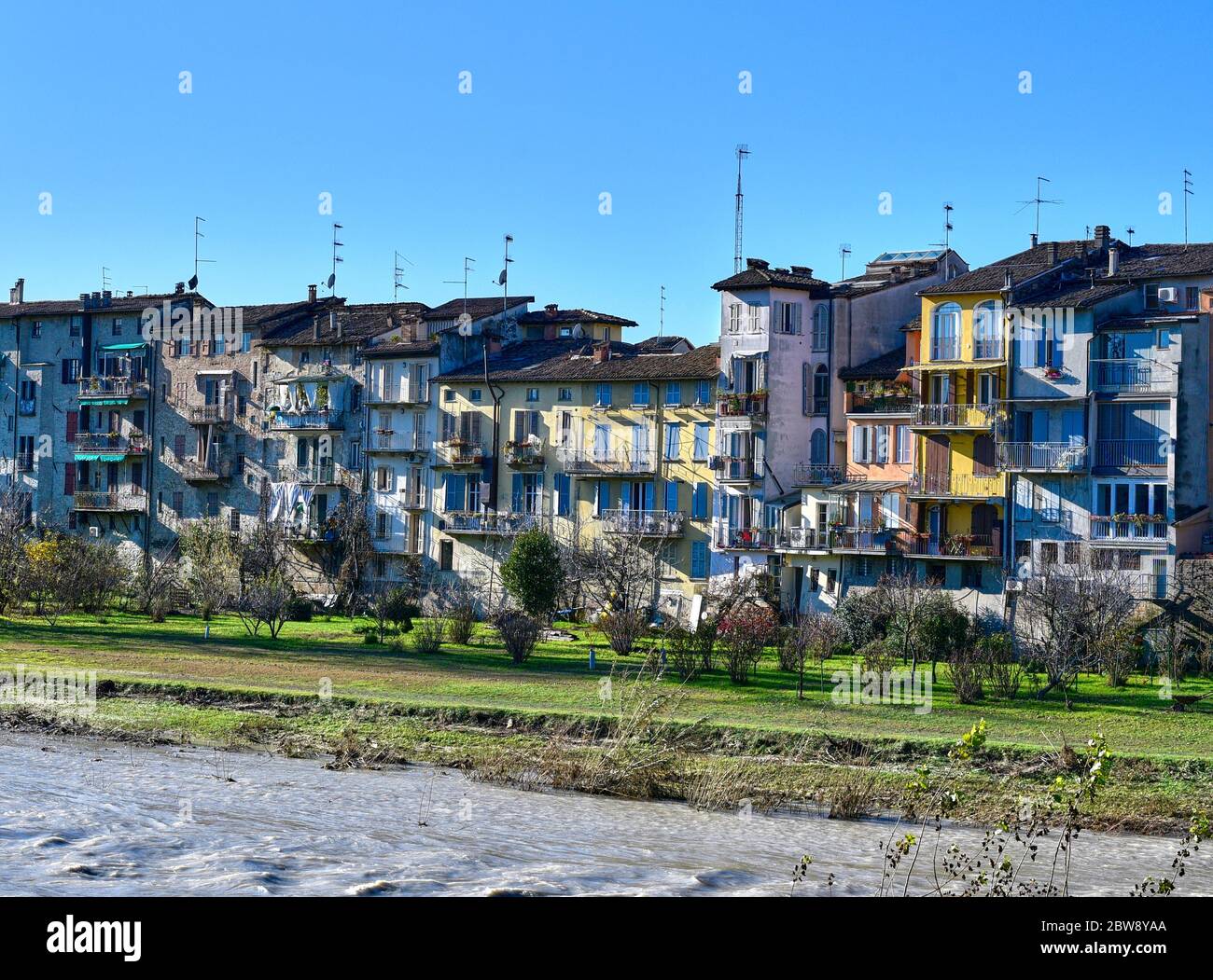 Vista delle pittoresche case colorate sul fiume Parma da Ponte di mezzo, a Parma, in una soleggiata giornata invernale Foto Stock