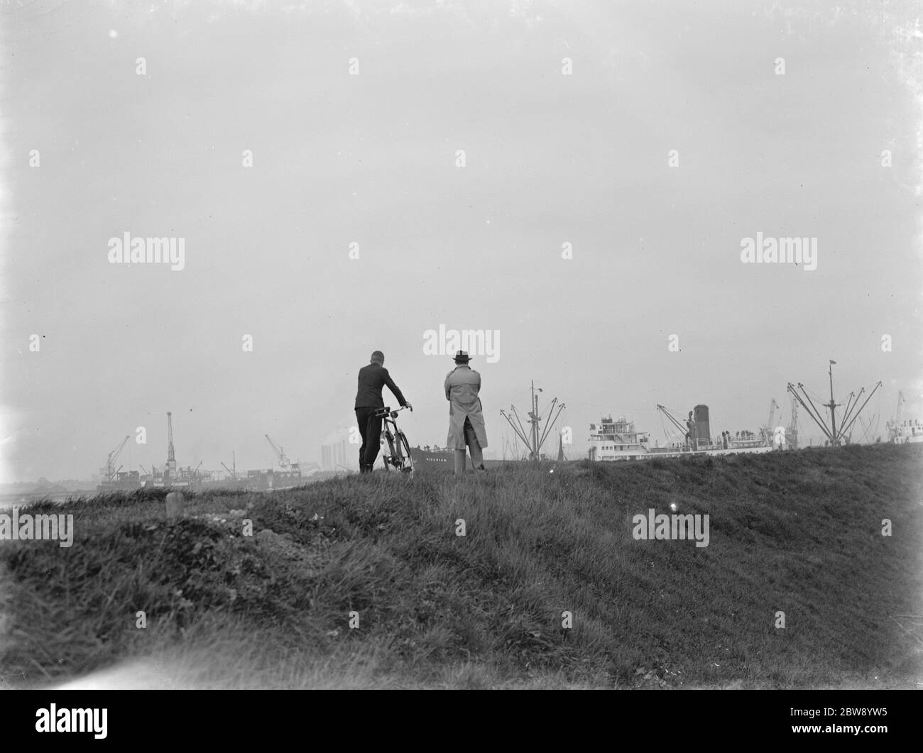 Due uomini in piedi su una collina guardano il Tamigi che spedisce a Greenhitthe , Kent . 1937 Foto Stock