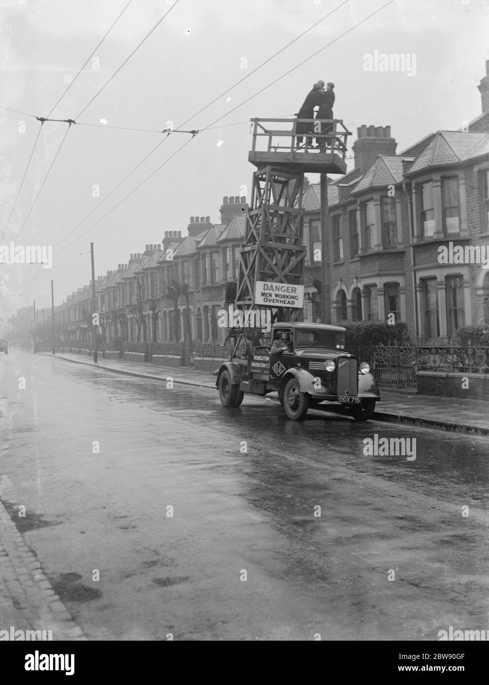 I lavoratori della Demolition and Construction Company Ltd utilizzano il proprio camion Bedford Tram Tower per lavorare sui cavi elettrici del filobus. 1937 . Foto Stock