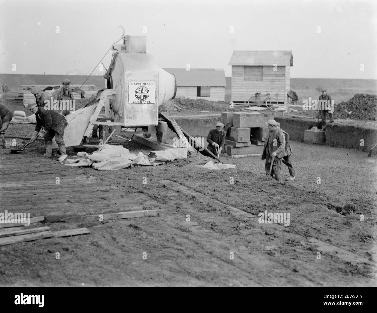 Operai che utilizzano un miscelatore per calcestruzzo sulla costruzione del Dartford Tunnel a Kent . 1937 Foto Stock