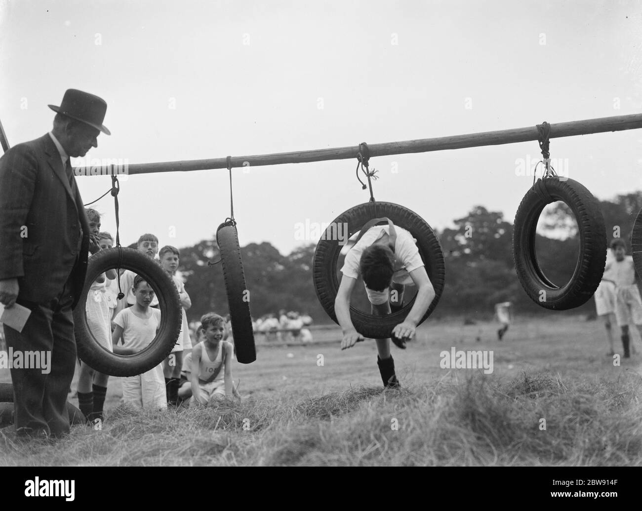 Giornata sportiva alla Eltham Central School di Londra . Immersione attraverso un pneumatico sul corso di ostacolo . 16 giugno 1937 Foto Stock