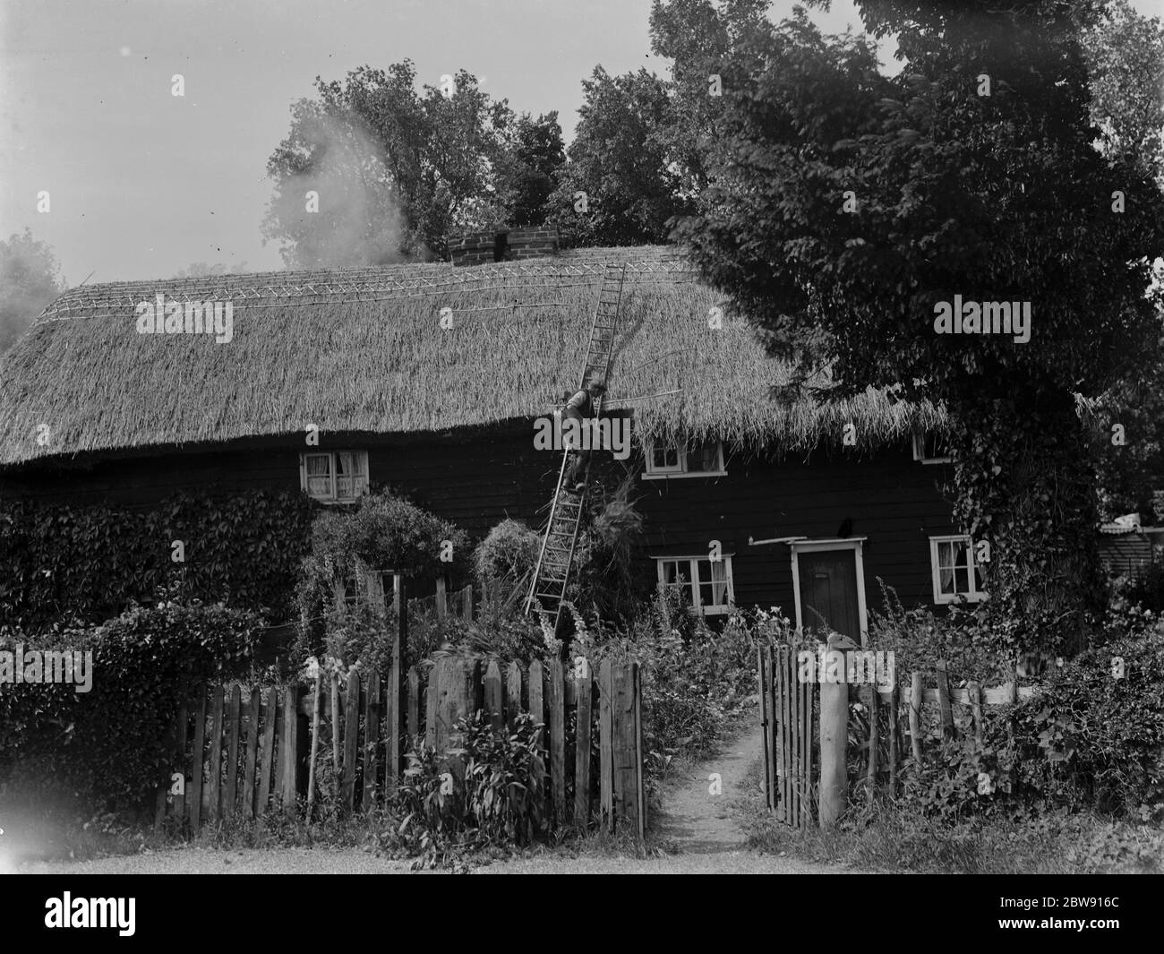 Un uomo che stenta il tetto di una casa a Hartley , Kent . 10 giugno 1937 . Foto Stock