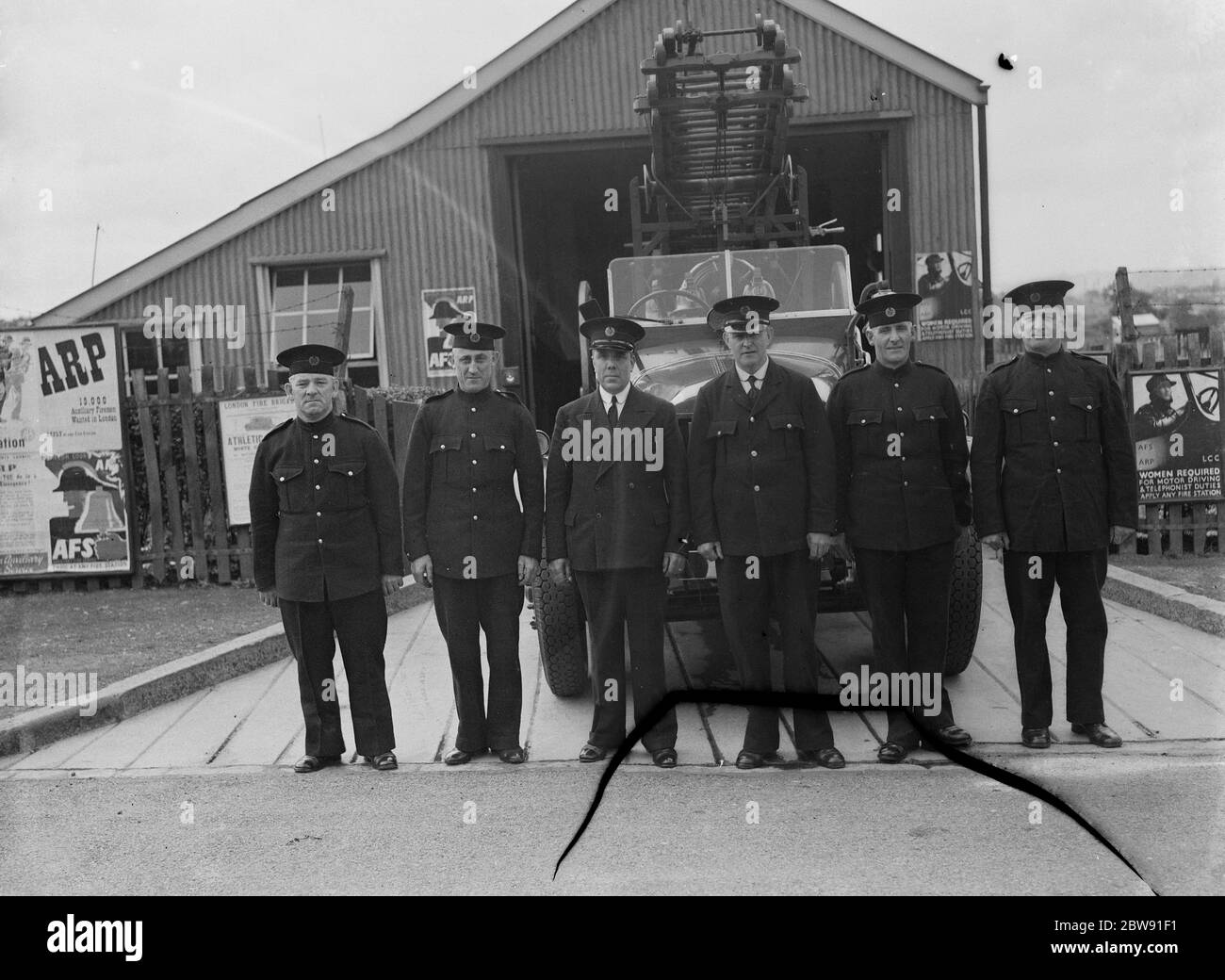 La Brigata del fuoco di Downham posa con il loro motore di fuoco. 1939 Foto Stock