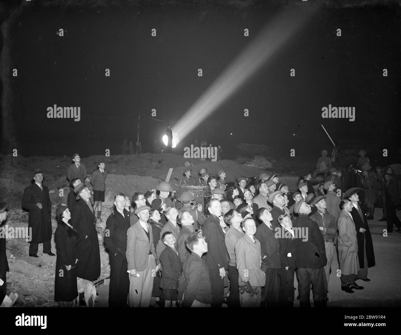 Una folla che guarda i proiettori da una batteria di artiglieria . 1938 Foto Stock