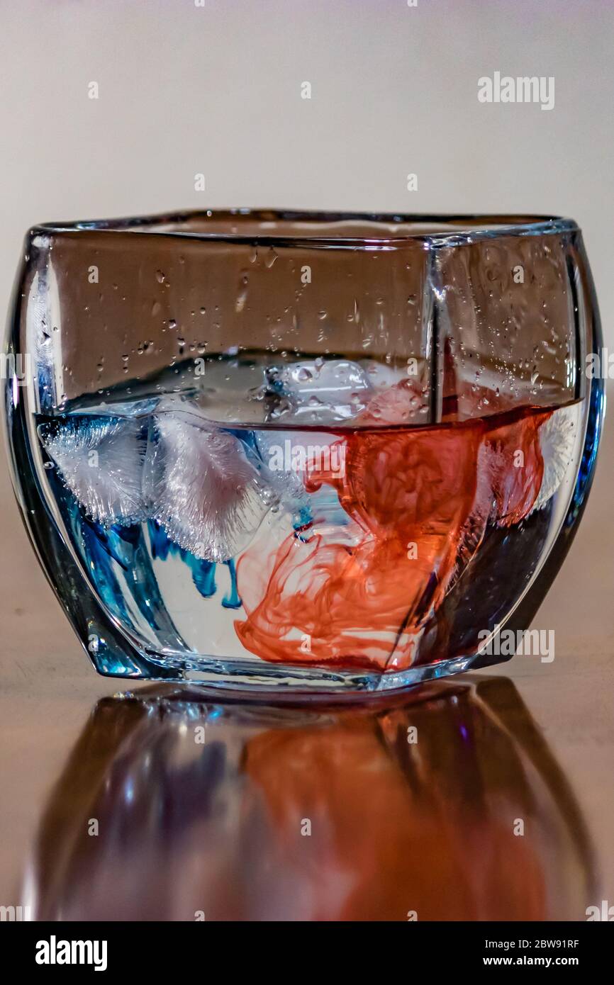 acqua con colorante rosso e blu nel recipiente in cristallo Foto Stock