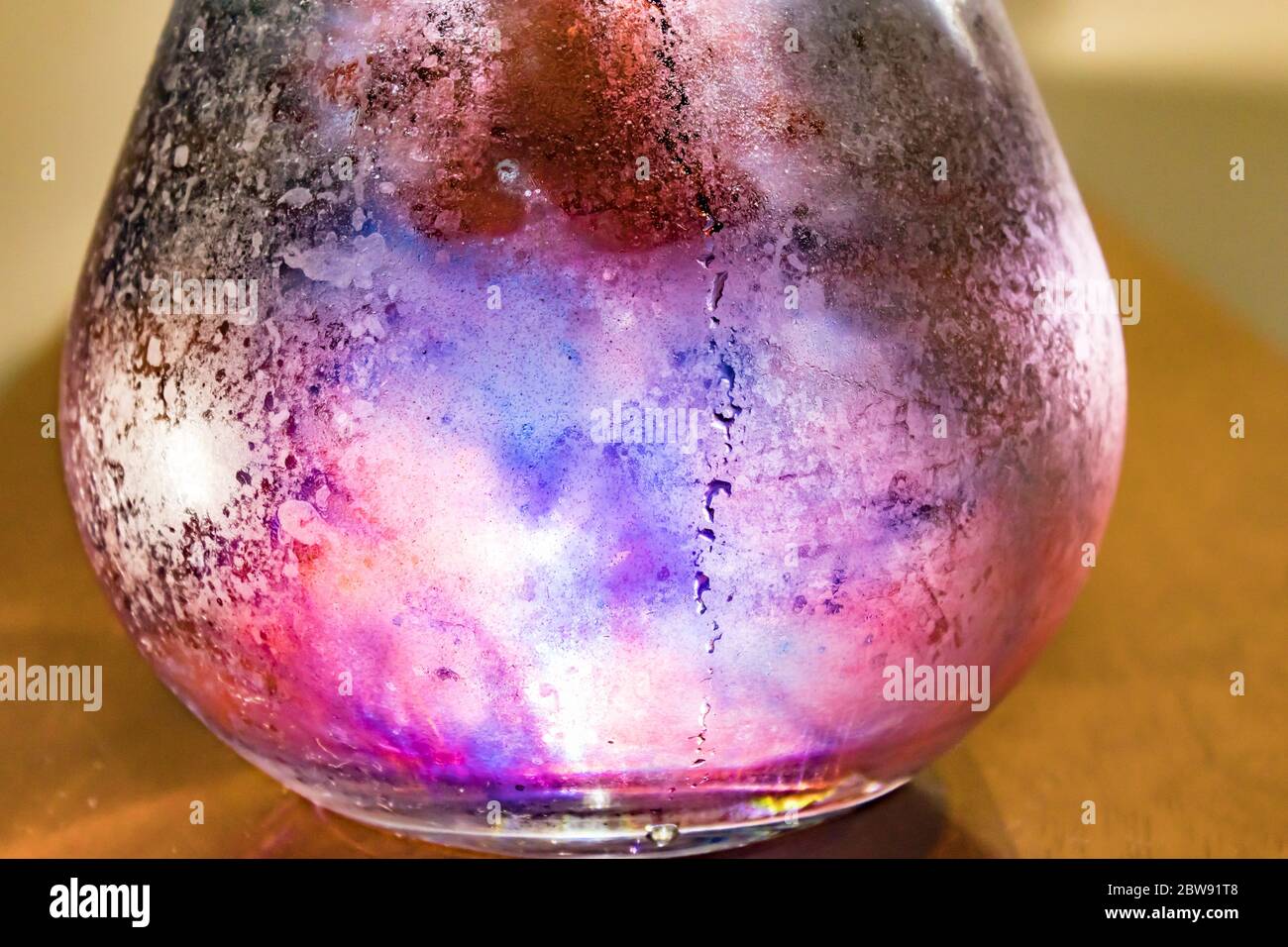 liquido colorato che rotola intorno in ciotola trasparente Foto Stock