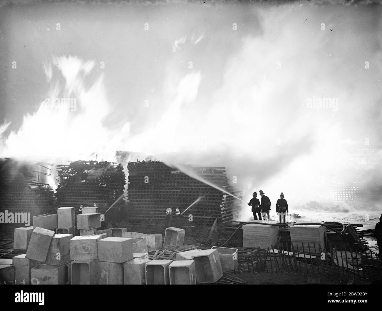 I vigili del fuoco addestrano i loro tubi sulle fiamme al fuoco del legname a Welling in Kent . 1938 Foto Stock