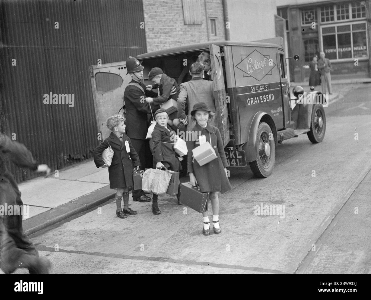 In risposta ai pericoli della guerra, il governo britannico ha lanciato un programma per evacuare i bambini dai principali centri urbani agli alloggi privati nelle aree più rurali . La foto mostra un poliziotto che aiuta i bambini dal retro di un furgone a Gravesend , Kent , durante le procedure di evacuazione . 1939 Foto Stock