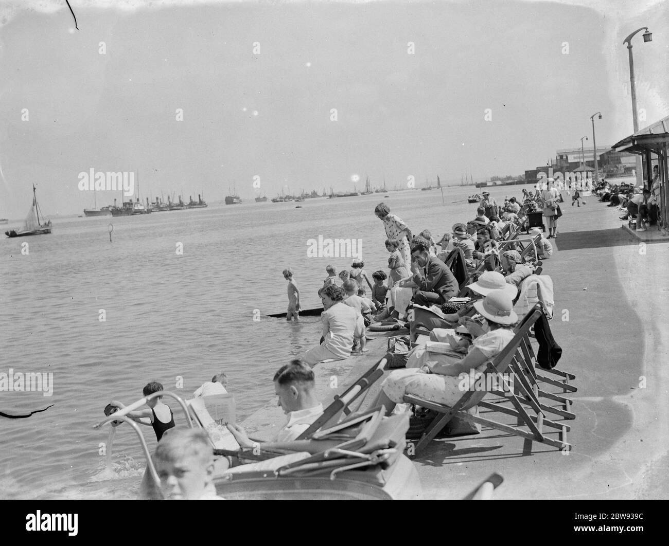 I viaggiatori sono fuori per godersi il sole e il Tamigi sulla passeggiata Gravesend, Kent . La navigazione sull'estuario del Tamigi può essere vista in lontananza. 1939 Foto Stock