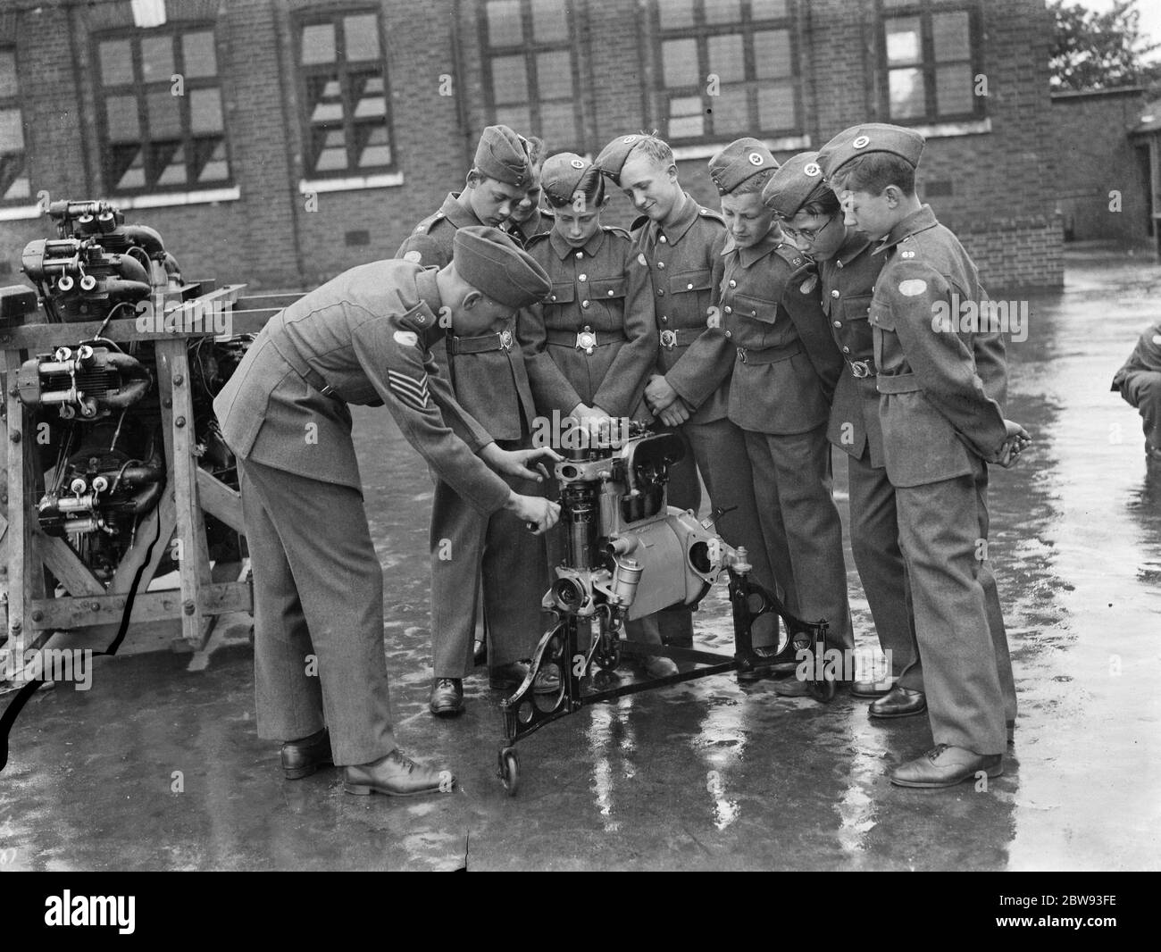 I nuovi cadetti dell'aria della croce stanno intorno ad un motore dell'aeroplano imparando circa la relativa meccanica . 1939 Foto Stock