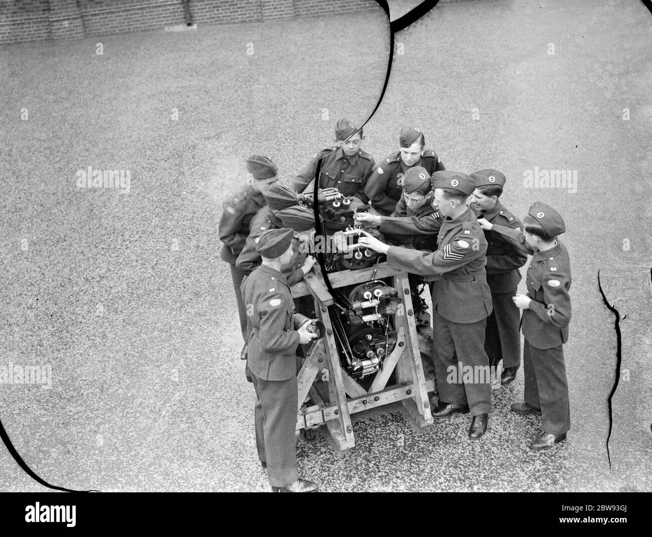 I nuovi cadetti dell'aria della croce stanno intorno ad un motore dell'aeroplano imparando circa la relativa meccanica . 1939 Foto Stock