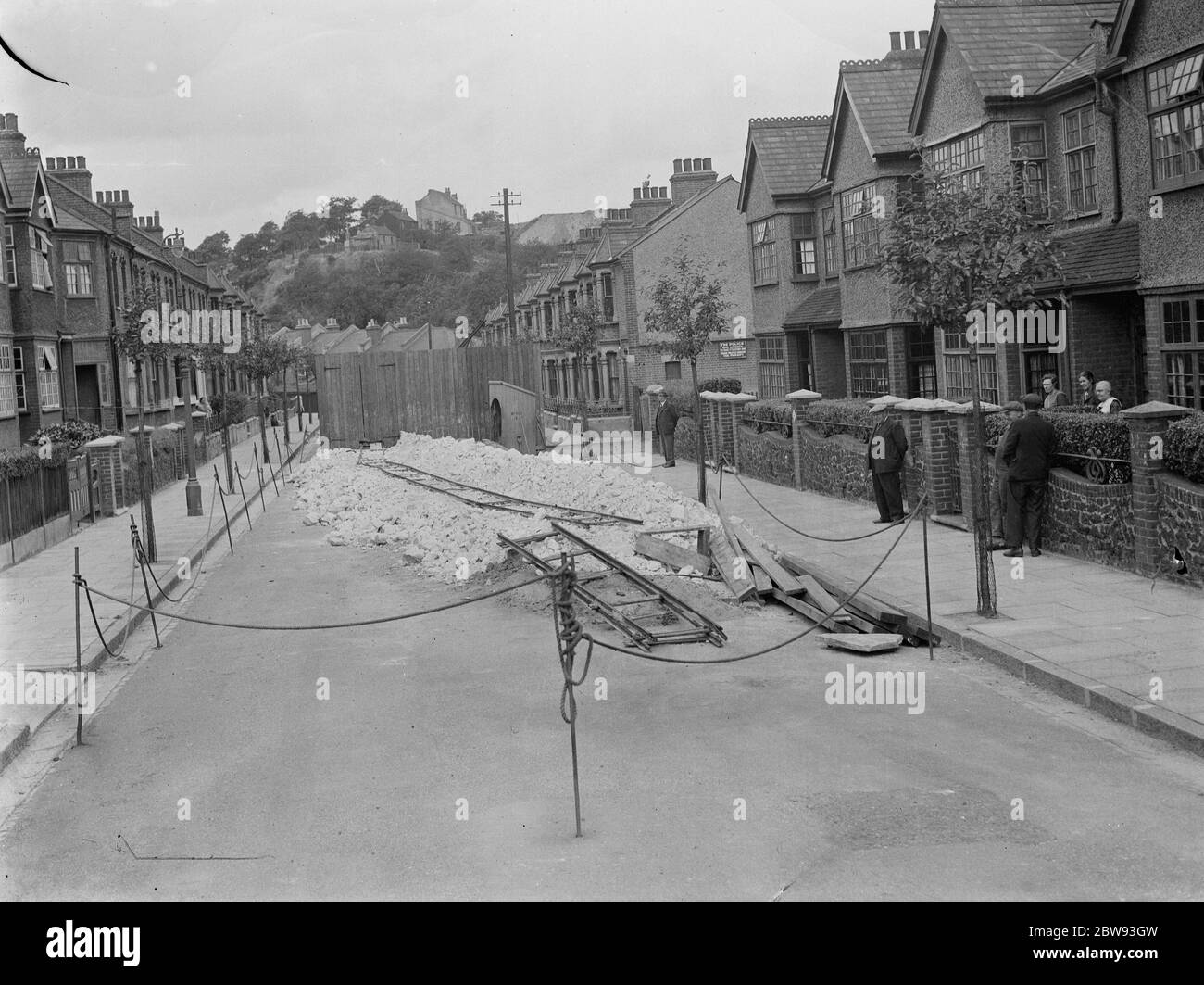I residenti di una strada in Plumstead guardano ciò che è rimasto della loro strada seguendo un po 'di cedimento . 1939 Foto Stock