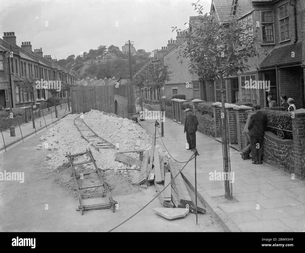 I residenti di una strada in Plumstead guardano ciò che è rimasto della loro strada seguendo un po 'di cedimento . 1939 Foto Stock