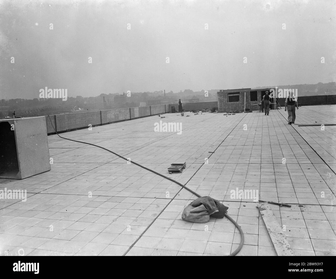 Lavoratori della Val De Travers Asphalt Limited , una società di pavimentazione , che lavora su un tetto a Greenwich , Londra . 1938 Foto Stock