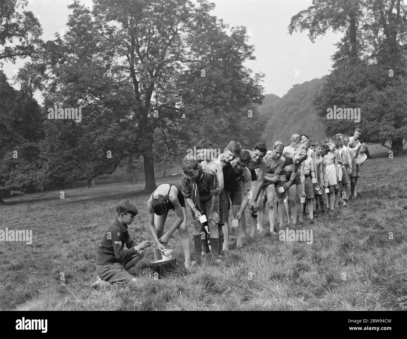 Scout al campo di Bexley scouts . Gli scout si allineano per ottenere un drink . 1937 Foto Stock