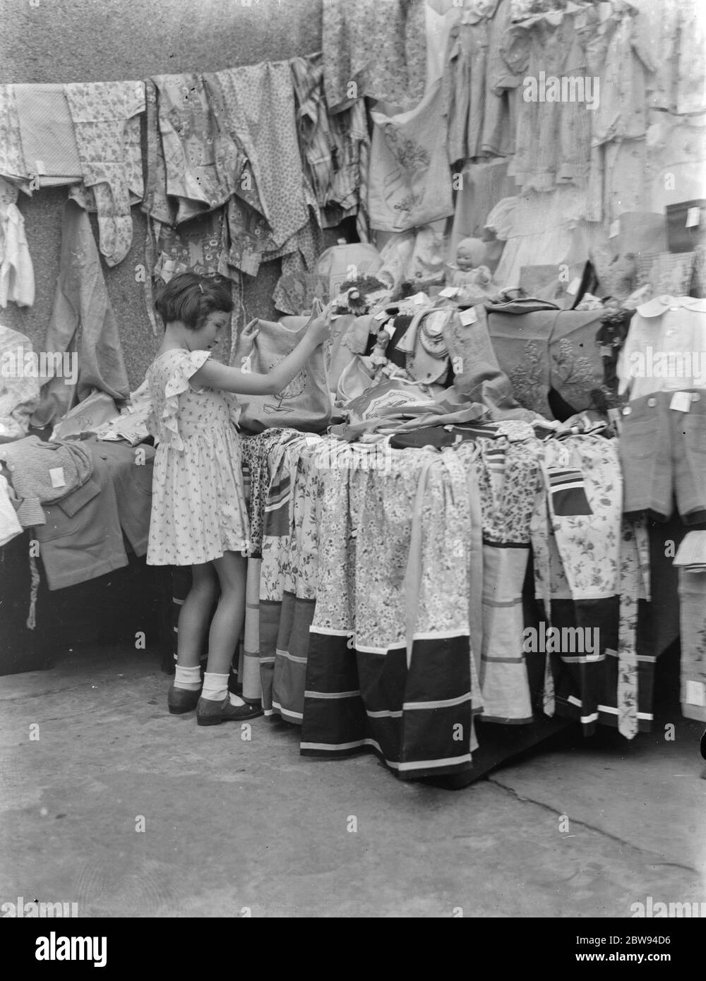 Petts Wood Fete in Kent . Una bambina in un chiosco di vestiti . 1937 . Foto Stock