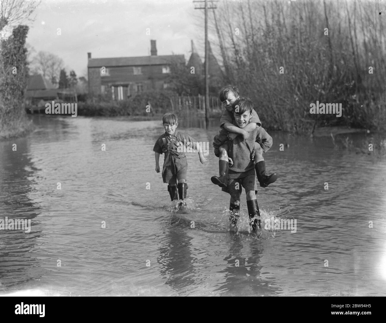 I ragazzi si sono guai attraverso le inondazioni a Beltring , Kent . 1936 Foto Stock