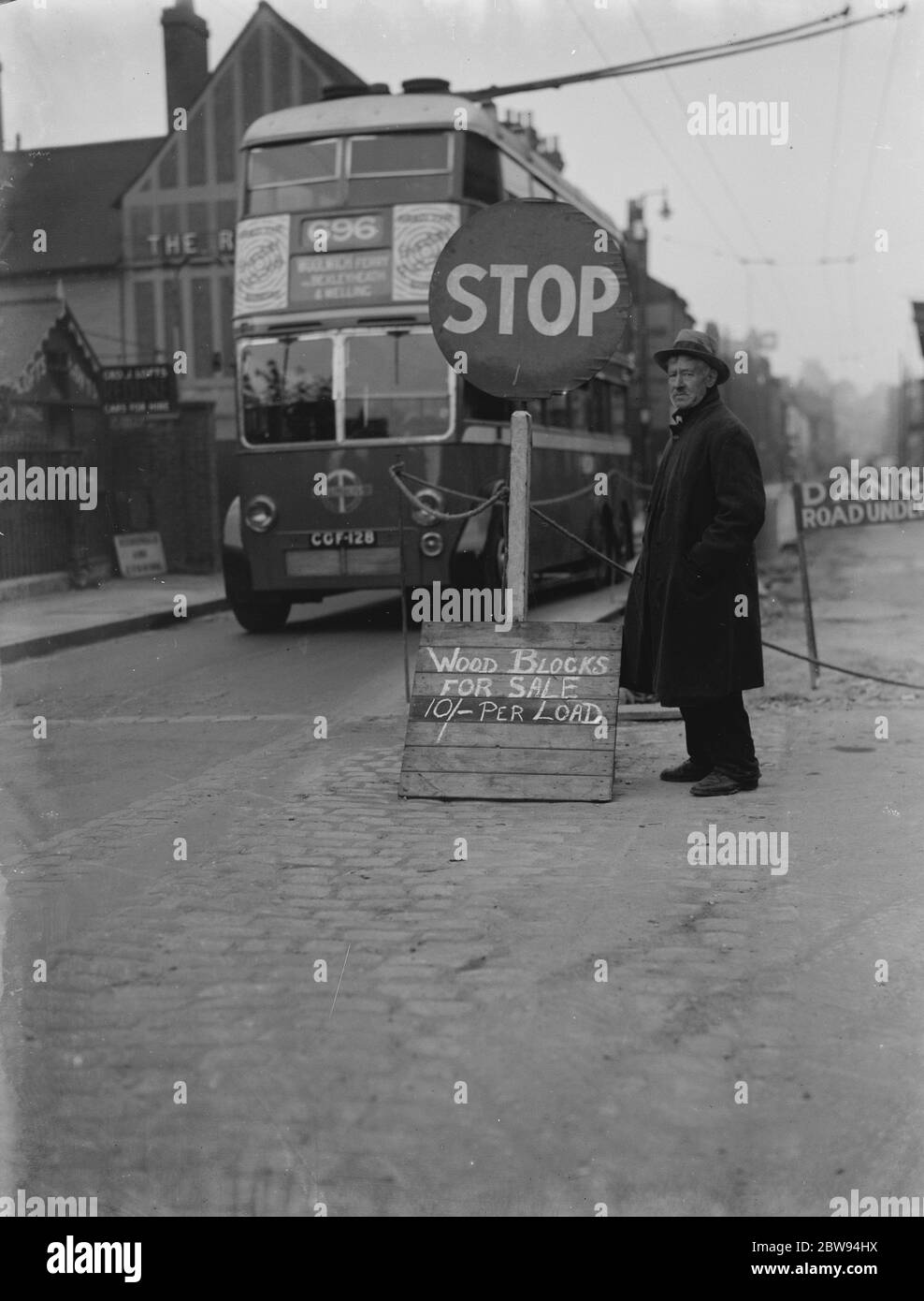 Un uomo con un cartello di legno in vendita sul lato della strada a Dartford, Kent. 1938 Foto Stock