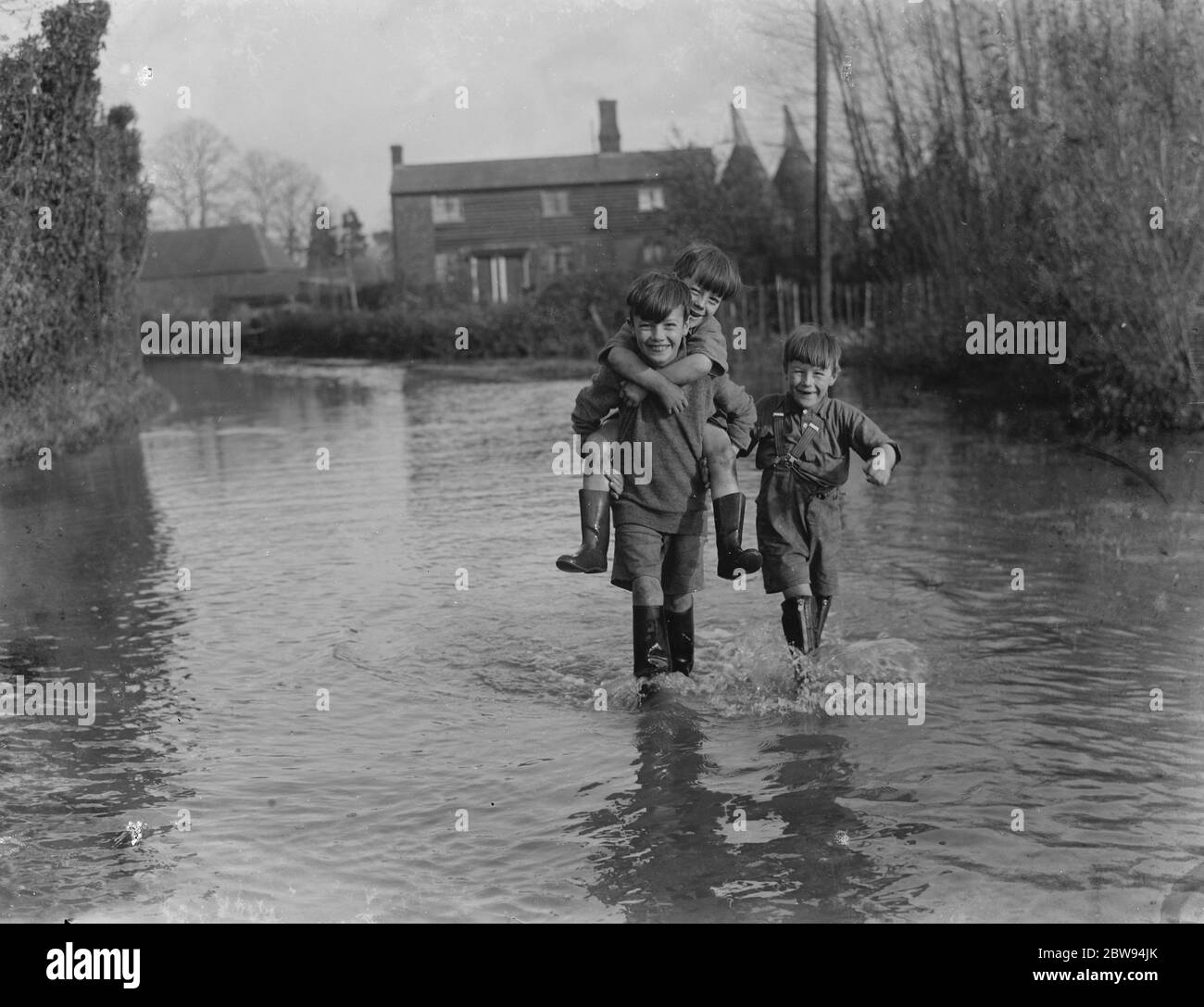 I ragazzi si fanno strada attraverso le inondazioni di Beltring , Kent . 1936 Foto Stock