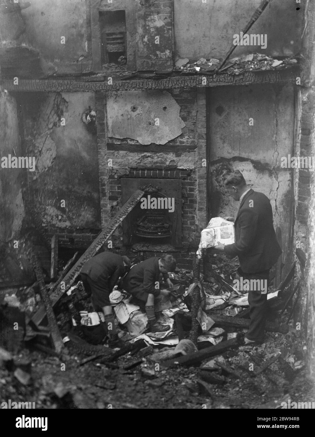 Guardando attraverso ciò che è lasciato dietro a seguito di un incendio in casa a Chelsfield , Kent . 1936 Foto Stock