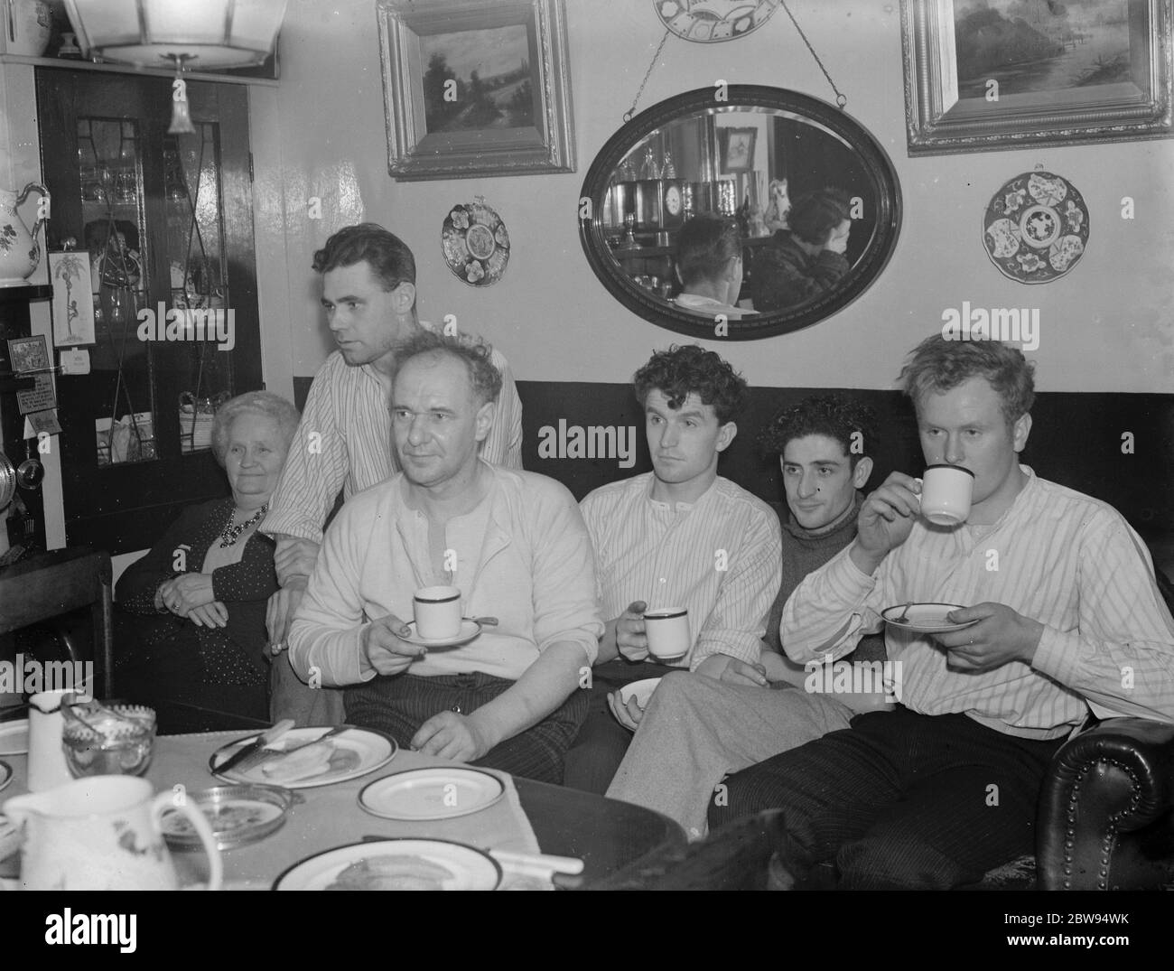 L'equipaggio di una barca coinvolta in una collisione sul Tamigi sono forniti tè caldo e biscotti dopo il loro Calvario . 1937 Foto Stock