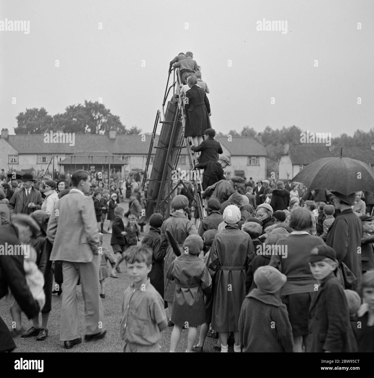 I bambini che si divertono a usare lo scivolo nel parco giochi per bambini di Crayford , Kent . 1936 Foto Stock