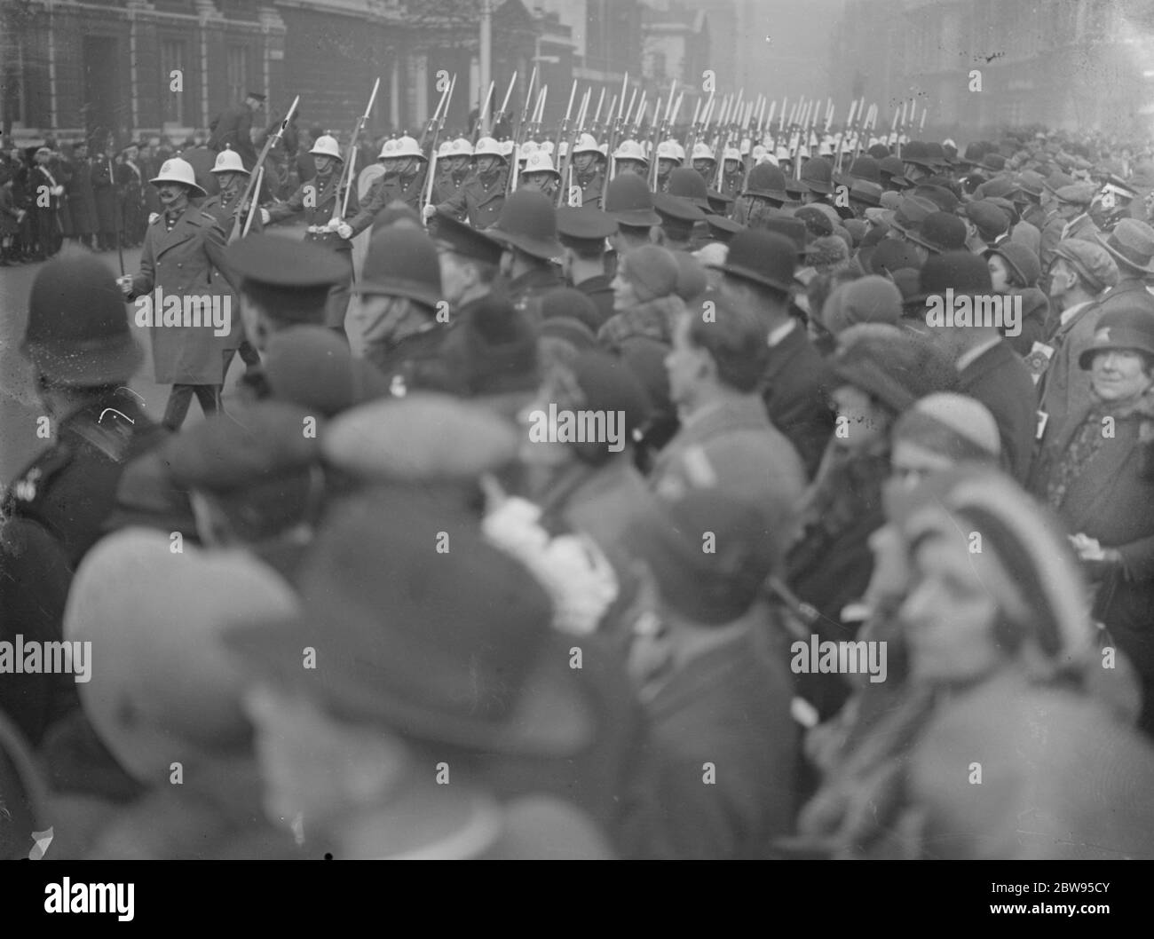 Quattordicesimo anniversario dell'armistizio celebrato a Londra . Il quattordicesimo anniversario dell'armistizio che ha portato a termine la Grande Guerra fu celebrato a Londra con un pellegrinaggio e un servizio nazionale al Cenotafe di Whitehall, cui parteciparono il Re e la Regina e altri membri della famiglia reale. Folle in coda al Cenotaph . 11 novembre 1932 Foto Stock