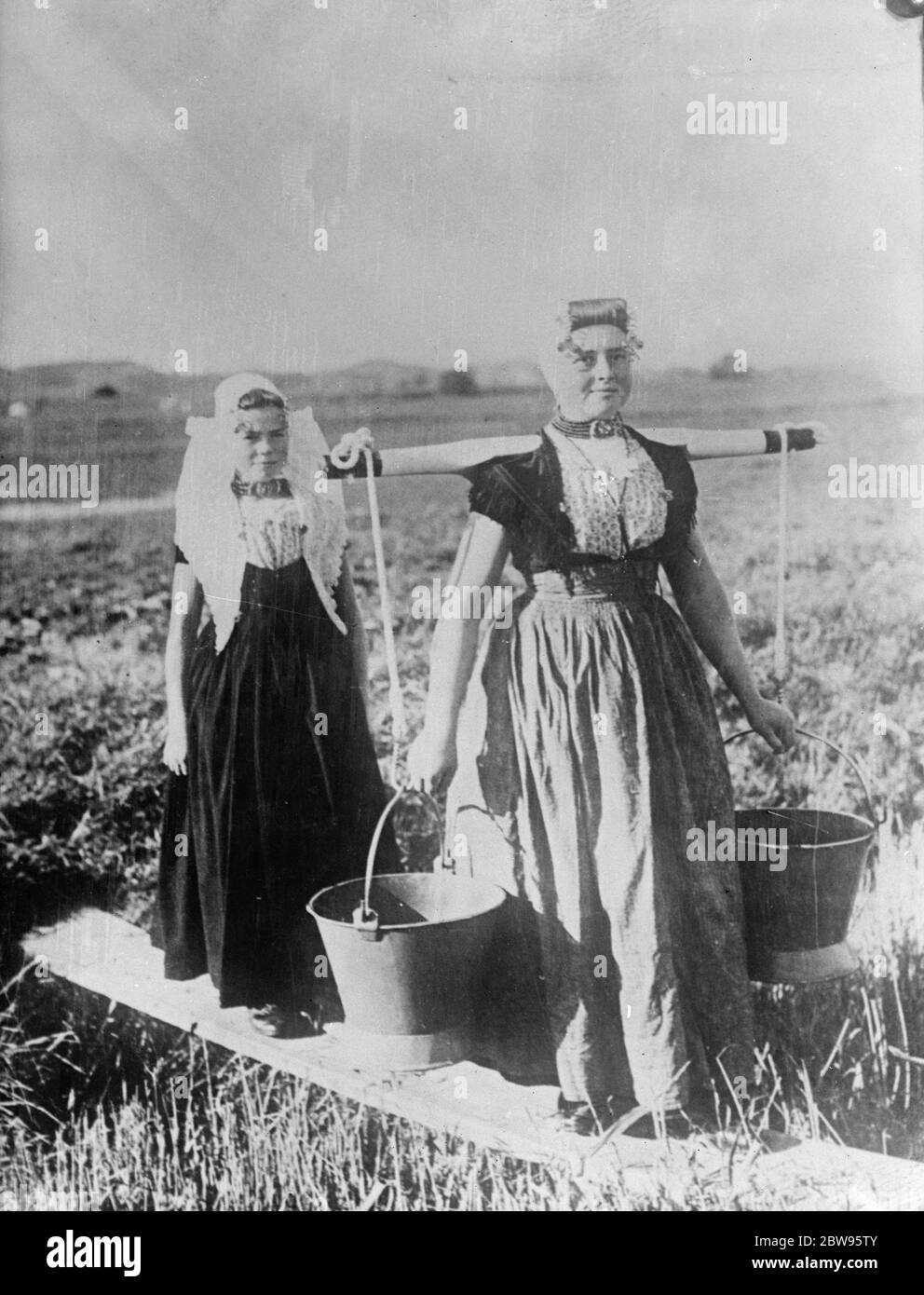 Due donne olandesi tipiche in abito nativo che porta le chiocci . 12 agosto 1932 Foto Stock