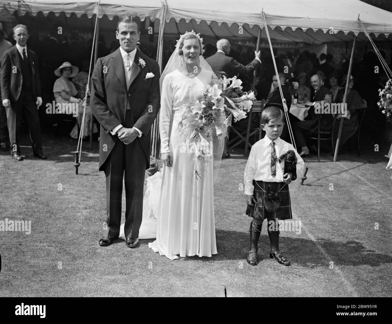 Gwen Sterry sposa rugby internazionale a Surbiton . La sig.na Gwen Sterry , il giocatore inglese di tennis da prato , è stata sposata con il sig. W M Simmers , il Rugby International scozzese , presso la chiesa di St Marks , Surbiton , Surrey . Un grande raduno di tennisti ha partecipato alla cerimonia e la signorina Betty Nuthall ha agito come una delle bridesmaids . La sposa e sposare con la pagina minuscola Maestro Hossack . 9 luglio 1932 Foto Stock