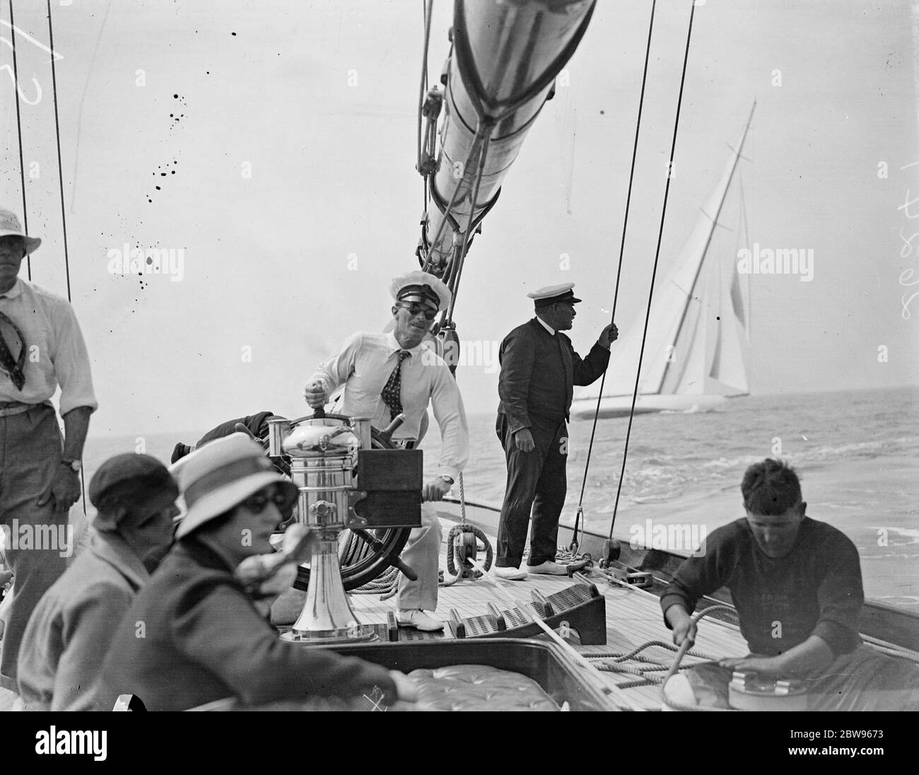 Shamrock V vince nella regata del Tamigi yacht club a Southend . Shamrock V, precedentemente di proprietà di Sir T Lipton , e ora di proprietà del signor T Sopwith , ha vinto la regata del Royal Thames Yacht Club su un percorso di quaranta miglia nell'estuario del Tamigi a Southend . La Candida, di proprietà del signor H A Andreae, era seconda, e la Britannia del re terza. Il signor H A Andreae al volante del suo yacht Candida con il signor Charles Nicholson a sinistra durante la gara. 11 luglio 1932 Foto Stock