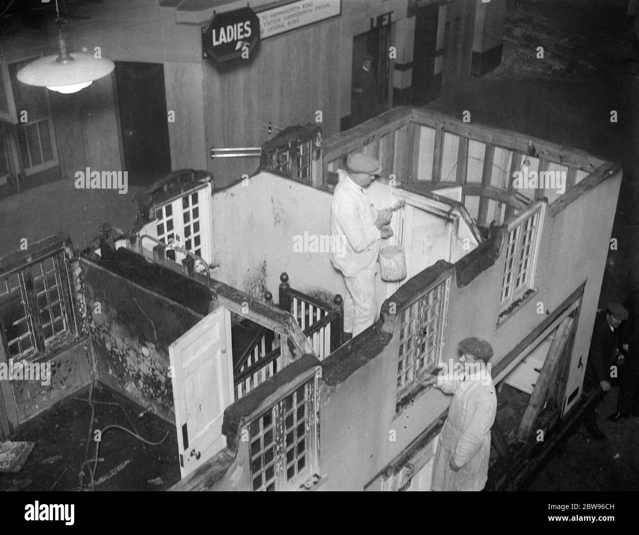 Riparazione della casa modello della principessa Elisabetta all'Olimpia . Subito dopo essere arrivati all' Olympia , Londra , la casa modello danneggiata presentata alla principessa Elisabetta dal popolo del Galles a Cardiff la scorsa settimana , che è stata danneggiata dal fuoco quando è stata portata in strada a Londra , i lavoratori hanno iniziato a lavorare per ripristinare il modello . Casa modello della principessa Elisabetta in riparazione all' Olympia , Londra . 23 marzo 1932 Foto Stock