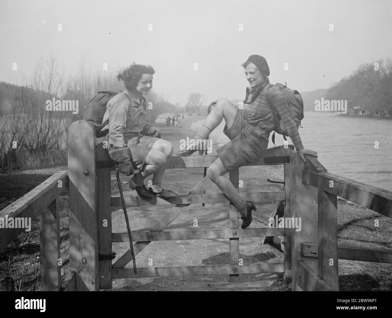La gioia della strada a Pasqua . Due ragazze escursionisti che hanno viaggiato nel Mystery Express escursionisti da Londra a Pangbourne , un posto di bellezza sul lato del Tamigi , godendo di un riposo su un cancello vicino al vialetto sotto il sole primaverile . 25 marzo 1932 Foto Stock
