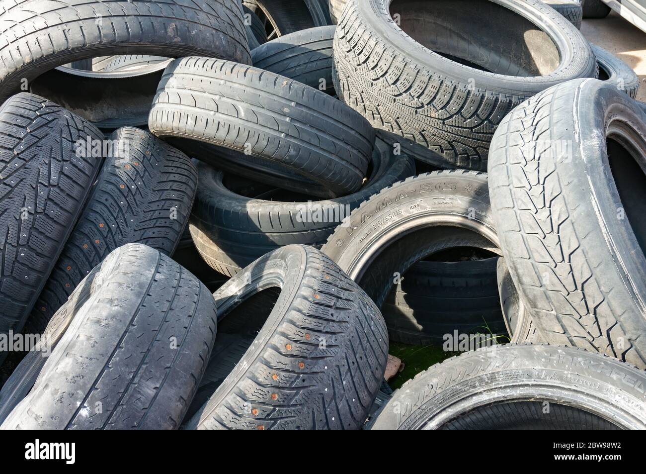 Un mucchio di vecchi pneumatici usati di gomma per auto di protezione al servizio o scarico con rifiuti e rifiuti pronti per il riciclaggio: San Pietroburgo, Russia, maggio 2020 Foto Stock