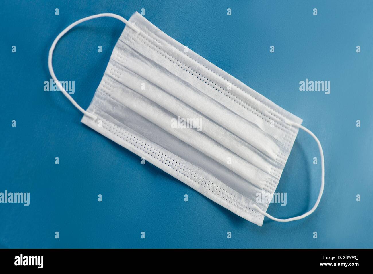 Immagine di una maschera facciale su sfondo blu. Foto Stock