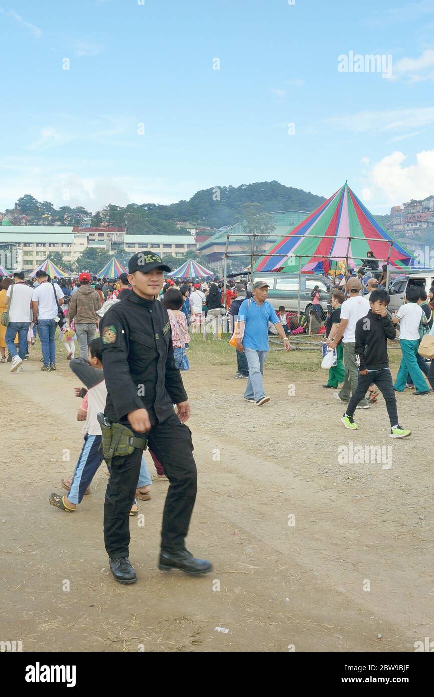 Una polizia maschile e persone in un evento a Benguet, Filippine, Sud-est asiatico. Foto scattata il 23 novembre 2019. Foto Stock