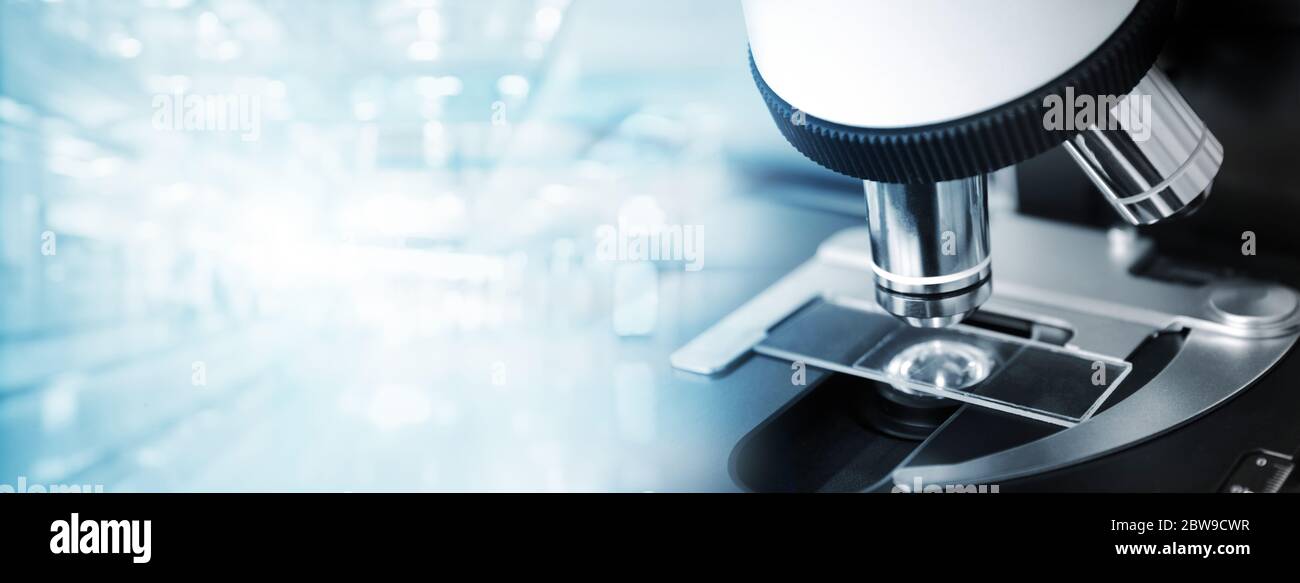 microscopio composto e vetrino in vetro in blu laboratorio morbido medico scienza web banner sfondo Foto Stock