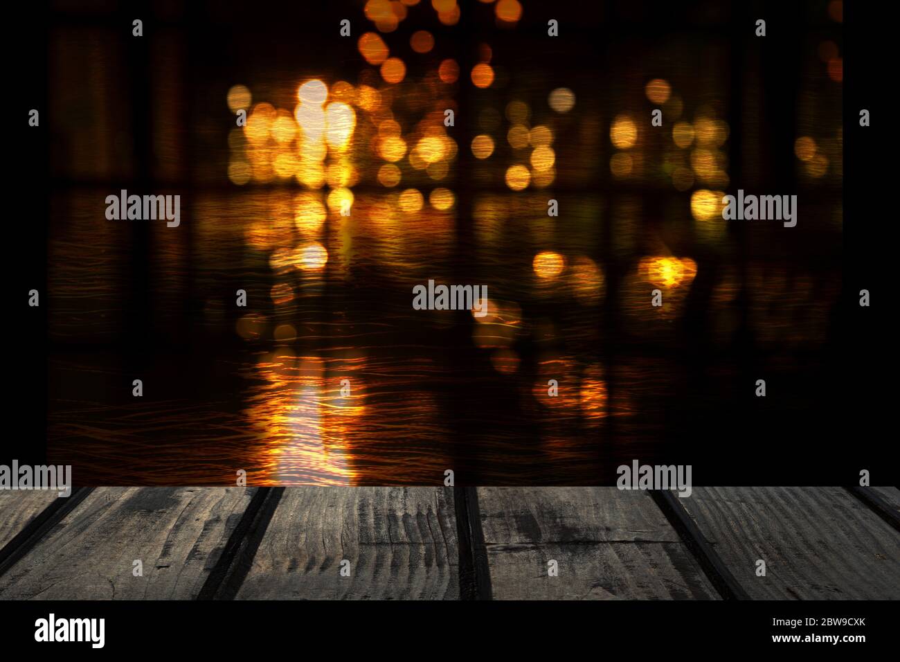 piano di tavolo in legno nero nel bar o pub con blur bokeh astratta luce della città nella notte buia per feste o sfondo festivo Foto Stock