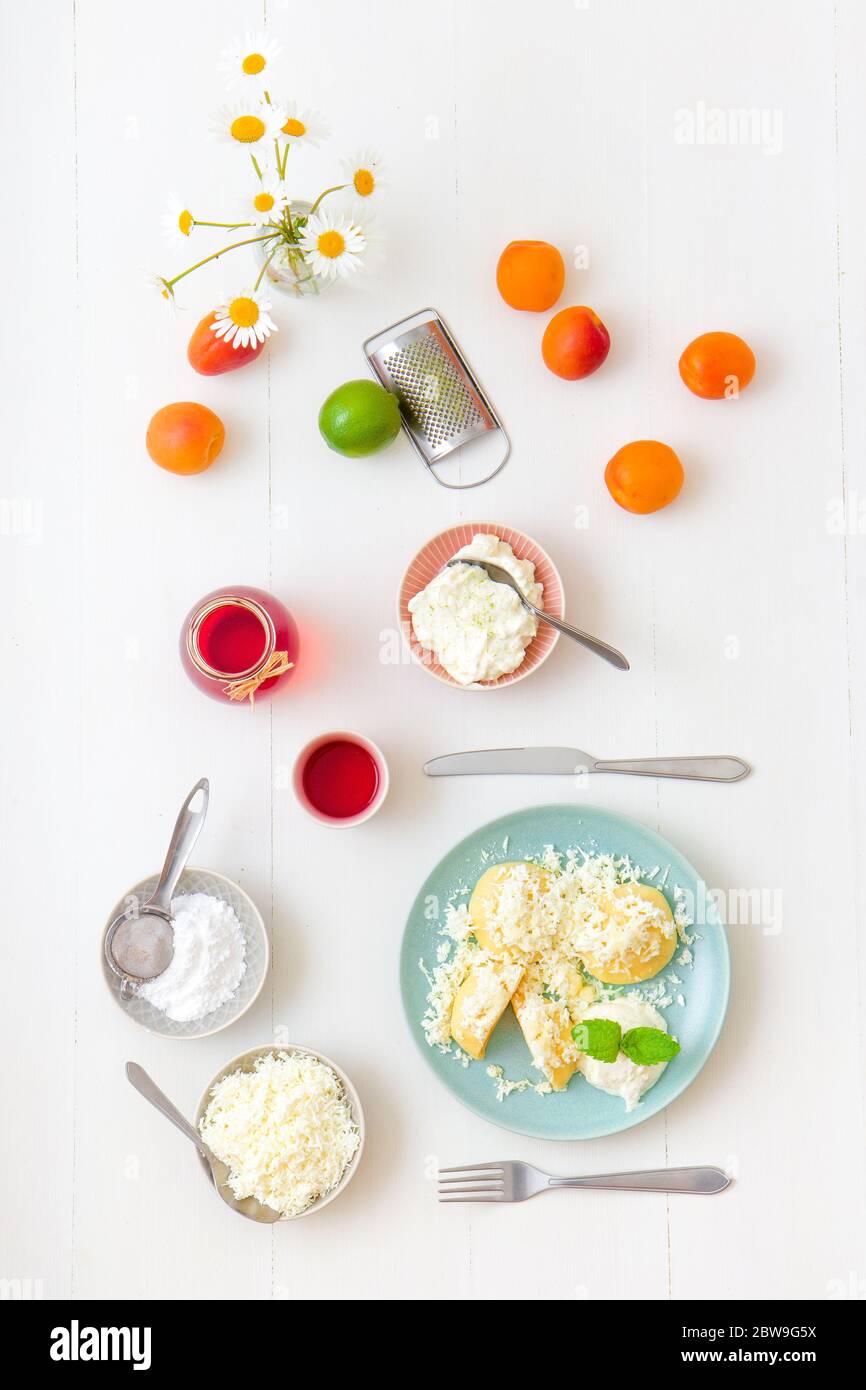 Gnocchi di frutta farciti con albicocche, cosparsi di formaggio caserario e zucchero, conditi con burro fuso, con crema fraiche con scorza di lime grattugiata An Foto Stock