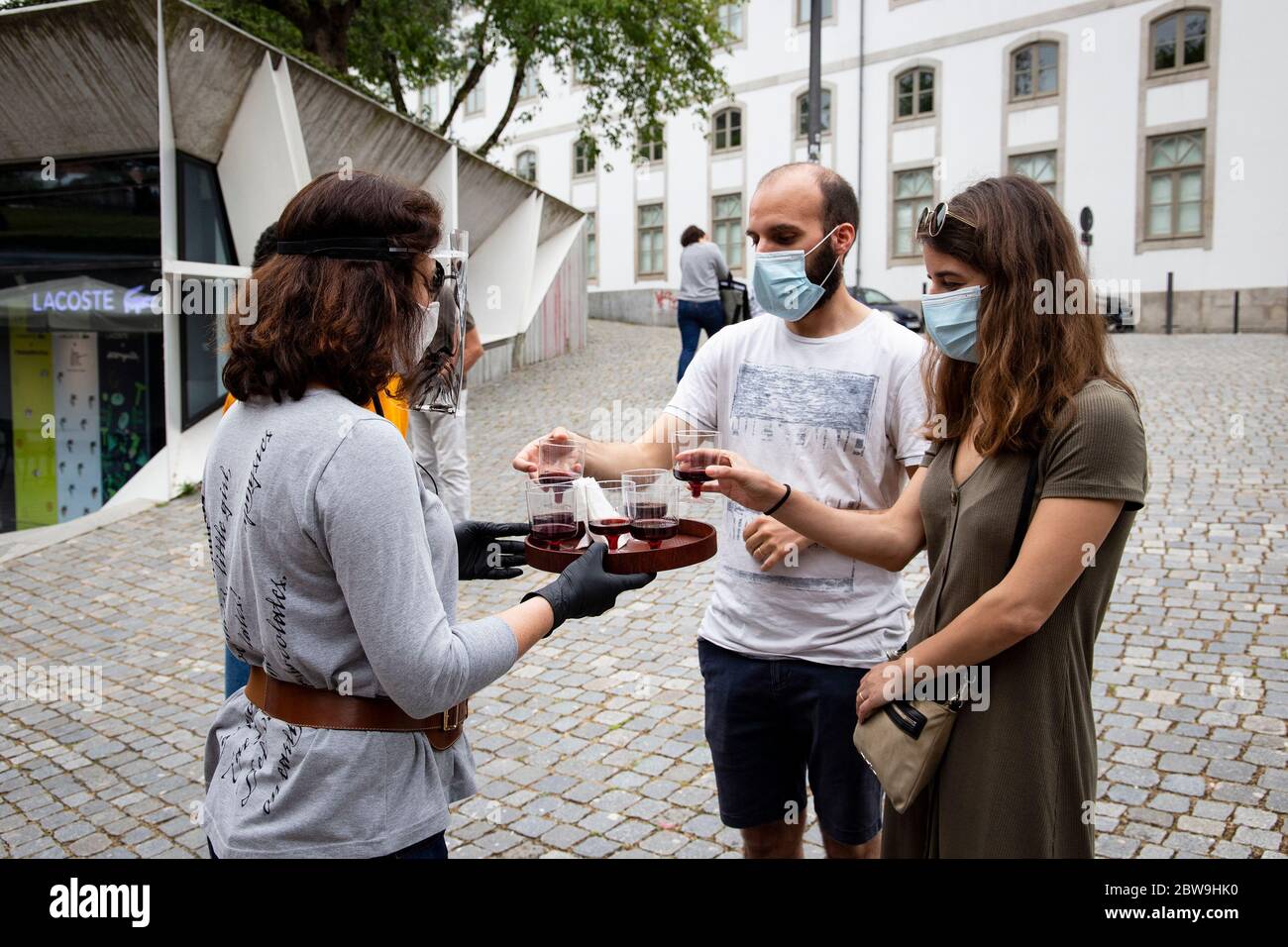 Porto, Portogallo. 30 maggio 2020. Il dipendente della libreria Lello offre un calice di Porto Wine fuori dalla libreria lello il giorno della riapertura di alcuni monumenti e luoghi turistici della città di Porto, Nella terza fase di deflazione che avverrà il 1 giugno in mezzo alla pandemia covid-19.l'eclettica e art noveau libreria Lello è una delle librerie più antiche, più belle e più visitate della città di Porto, E per un certo tempo è stato associato con i libri dall'autore J.K Rowling, da Harry Potter. Credit: SOPA Images Limited/Alamy Live News Foto Stock