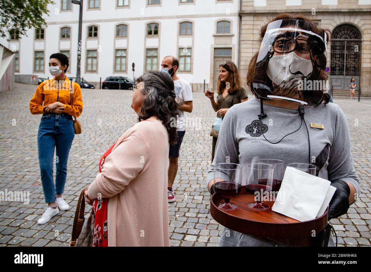 Porto, Portogallo. 30 maggio 2020. Il dipendente della libreria Lello offre un calice di Porto Wine fuori dalla libreria lello il giorno della riapertura di alcuni monumenti e luoghi turistici della città di Porto, Nella terza fase di deflazione che avverrà il 1 giugno in mezzo alla pandemia covid-19.l'eclettica e art noveau libreria Lello è una delle librerie più antiche, più belle e più visitate della città di Porto, E per un certo tempo è stato associato con i libri dall'autore J.K Rowling, da Harry Potter. Credit: SOPA Images Limited/Alamy Live News Foto Stock