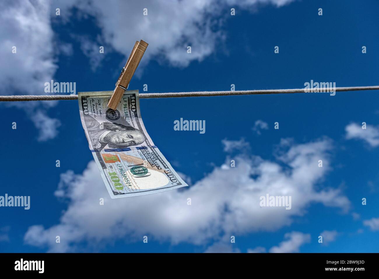 Un centinaio di dollari di bolletta che asciuga su stendibiancheria contro cielo Foto Stock